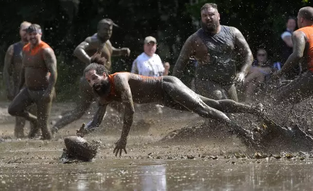 Andre Rioux, of Nashua, N.H., dives for the ball in a football game at the Mud Bowl in North Conway, N.H., Saturday, Sept. 7, 2024. (AP Photo/Robert F. Bukaty)