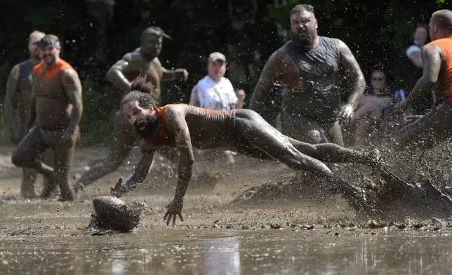 Andre Rioux, of Nashua, N.H., dives for the ball in a football game at the Mud Bowl in North Conway, N.H., Saturday, Sept. 7, 3024. (AP Photo/Robert F. Bukaty)