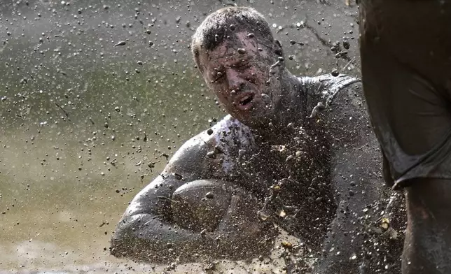 Mike Woodworth, of the the Muddas, goes down after making a catch in a football game at the Mud Bowl in North Conway, N.H., Saturday, Sept. 7, 3024. (AP Photo/Robert F. Bukaty)