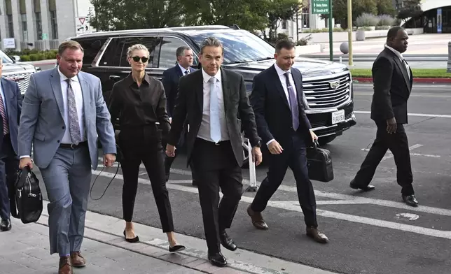 Lachlan Murdoch, center, and his wife Sarah arrive at the Second Judicial District Court in Reni, Nev. on Monday Sept. 16, 2024. (AP Photo/Andy Barron)