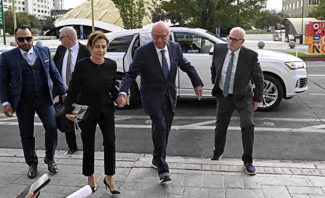 Rupert Murdoch, center, and his wife Elena Zhukova Murdoch arrive at the Second Judicial District Court in Reno, Nev., Monday Sept. 16, 2024. (AP Photo/Andy Barron)