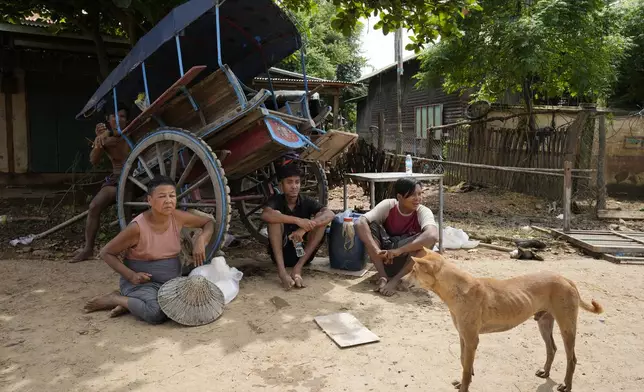 Local residents rest near a flooded road in Naypyitaw, Myanmar, Saturday, Sept. 14, 2024. (AP Photo/Aung Shine Oo)