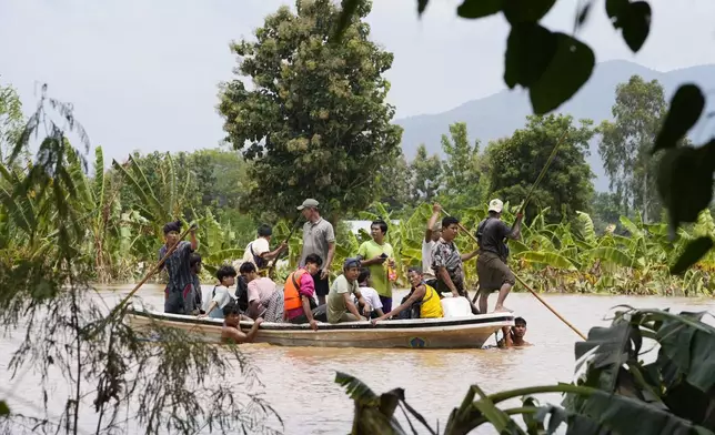 Local residents travel by boat on a flooded road in Naypyitaw, Myanmar, Saturday, Sept. 14, 2024. (AP Photo/Aung Shine Oo)