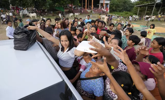 Flood victims receive relief supplies from a private donor in Naypyitaw, Myanmar, Sunday, Sept. 15, 2024. (AP Photo/Aung Shine Oo)