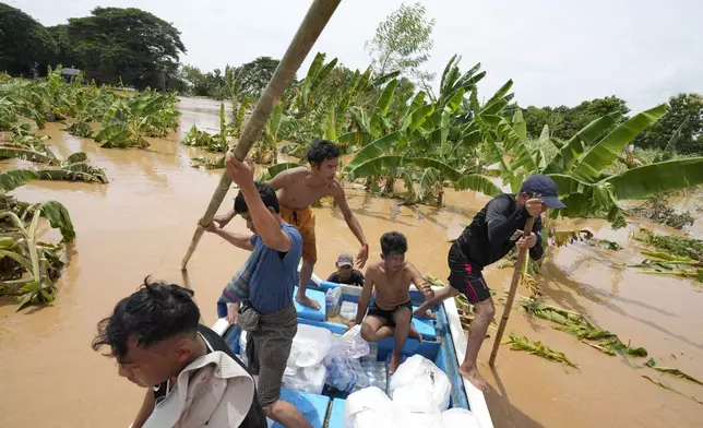 Local residents travel by boat on a flooded road in Naypyitaw, Myanmar, Saturday, Sept. 14, 2024. (AP Photo/Aung Shine Oo)