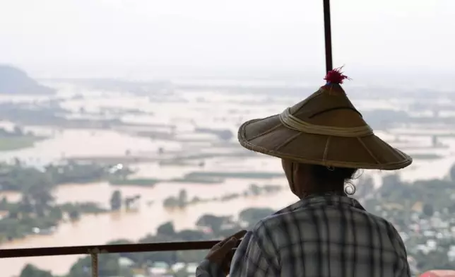 A woman looks out at flooded areas in Naypyitaw, Myanmar, Sunday, Sept. 15, 2024. (AP Photo/Aung Shine Oo)