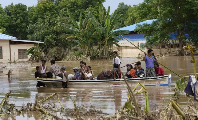 Local residents travel by boat on a flooded road, in Naypyitaw, Myanmar, Tuesday, Sept. 17, 2024. (AP Photo/Aung Shine Oo)