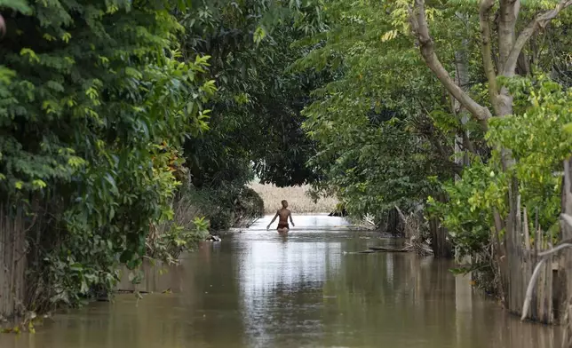 A boy wades through a flooded road, in Naypyitaw, Myanmar, Tuesday, Sept. 17, 2024. (AP Photo/Aung Shine Oo)