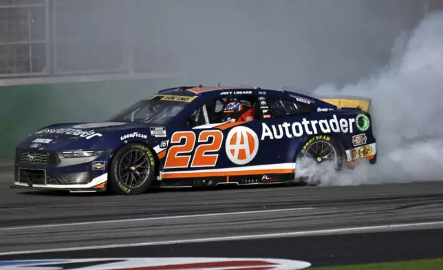 Joey Logano celebrates with a burnout after winning a NASCAR Cup Series auto race at Atlanta Motor Speedway, Sunday, Sept. 8, 2024, in Hampton, Ga. (Hyosub Shin/Atlanta Journal-Constitution via AP)