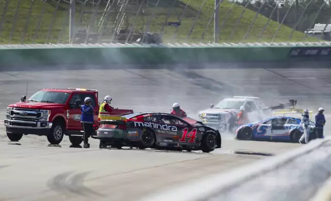 Chase Briscoe (14) is involved in a wreck with Kyle Larson (5) around Turn 2 during a NASCAR Cup Series auto race Sunday, Sept. 8, 2024, in Hampton, Ga. (AP Photo/Greg McWilliams)