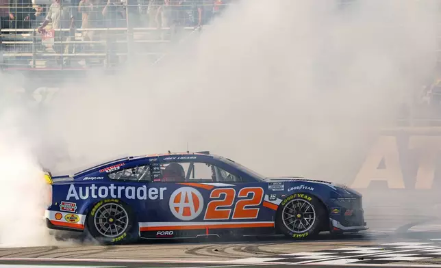 Joey Logano (22) does a burnout near the finish line after winning a NASCAR Cup Series auto race Sunday, Sept. 8, 2024, in Hampton, Ga. (AP Photo/Jason Allen)