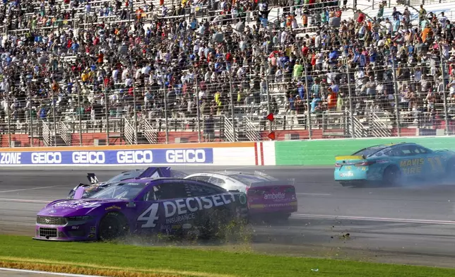 Josh Berry (4), Zane Smith (71) and Denny Hamlin (11) are involved in a wreck while coming out of Turn 4 during a NASCAR Cup Series auto race Sunday, Sept. 8, 2024, in Hampton, Ga. (AP Photo/Skip Williams)