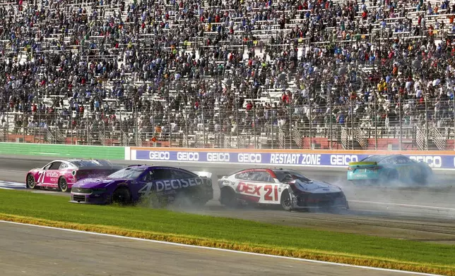 Josh Berry (4), Zane Smith (71), Harrison Burton (21) and Denny Hamlin (11) are involved in a wreck while coming out of Turn 4 during a NASCAR Cup Series auto race Sunday, Sept. 8, 2024, in Hampton, Ga. (AP Photo/Skip Williams)