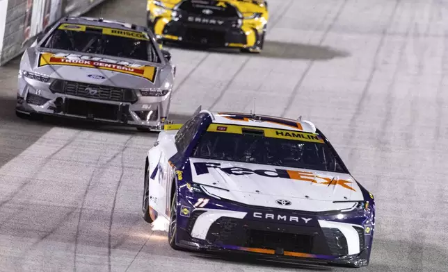 Denny Hamlin (11) leads Chase Briscoe (14) and Christopher Bell (20) during a NASCAR Cup Series auto race, Saturday, Sept. 21, 2024, in Bristol, Tenn. (AP Photo/Wade Payne)