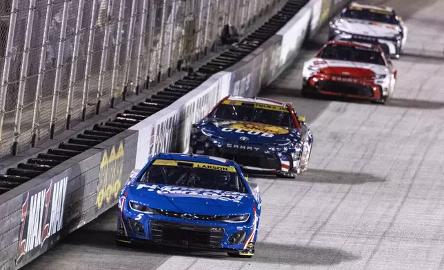 Kyle Larson (5) leads Martin Truex Jr. (19) during a NASCAR Cup Series auto race, Saturday, Sept. 21, 2024, in Bristol, Tenn. (AP Photo/Wade Payne)