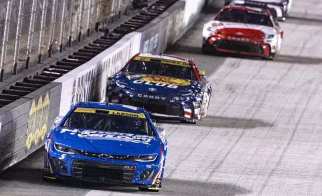 Kyle Larson (5) leads Martin Truex Jr. (19) during a NASCAR Cup Series auto race, Saturday, Sept. 21, 2024, in Bristol, Tenn. (AP Photo/Wade Payne)