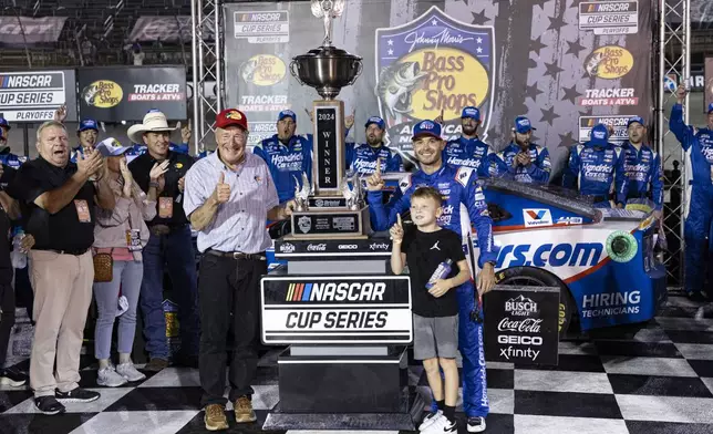 Kyle Larson, center back right, celebrates with his son Owen, center front right, and Bass Pro Shops founder Johnny Morris, center left, after a NASCAR Cup Series auto race, Saturday, Sept. 21, 2024, in Bristol, Tenn. (AP Photo/Wade Payne)