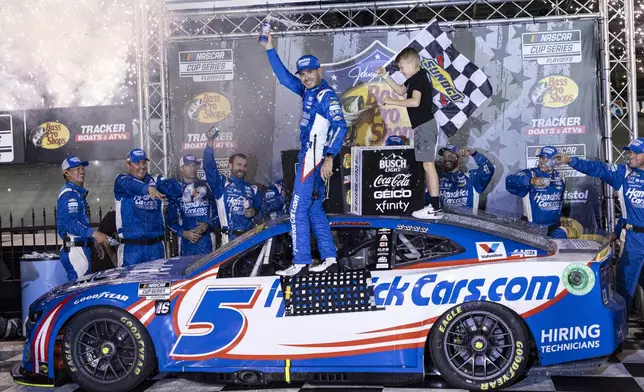 Kyle Larson, center, celebrates with his son Owen after winning a NASCAR Cup Series auto race, Saturday, Sept. 21, 2024, in Bristol, Tenn. (AP Photo/Wade Payne)