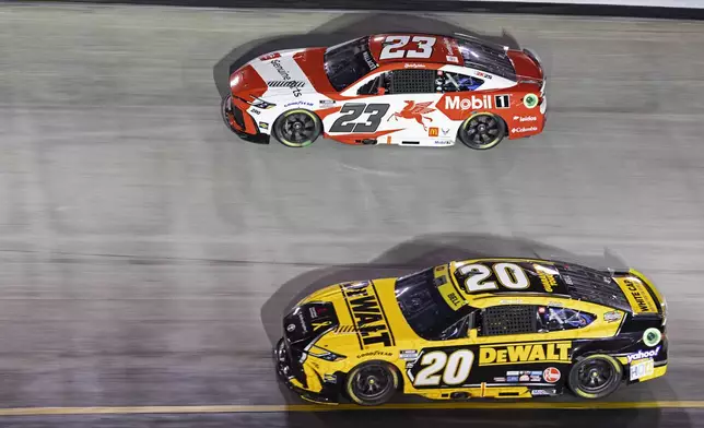 Christopher Bell (20) and Bubba Wallace (23) battle during a NASCAR Cup Series auto race, Saturday, Sept. 21, 2024, in Bristol, Tenn. (AP Photo/Wade Payne)