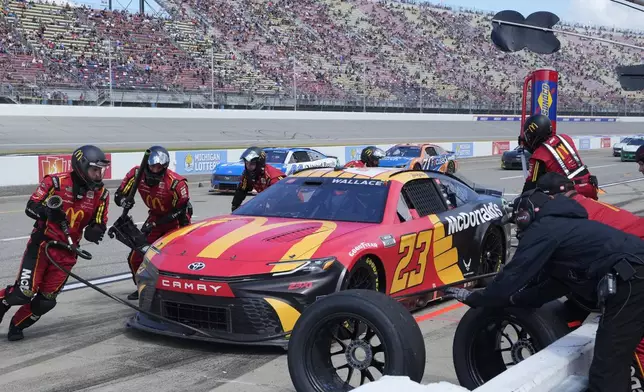 Bubba Wallace makes a pitstop during a NASCAR Cup Series auto race at Michigan International Speedway, Monday, Aug. 19, 2024, in Brooklyn, Mich. (AP Photo/Carlos Osorio)