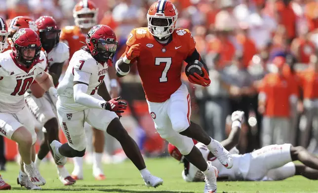 Clemson running back Phil Mafah (7) runs past North Carolina State safety Bishop Fitzgerald (7) and linebacker Caden Fordham (10) for a 38-yard touchdown during the first half of an NCAA college football game Saturday, Sept. 21, 2024, in Clemson, S.C. (AP Photo/Artie Walker Jr.)