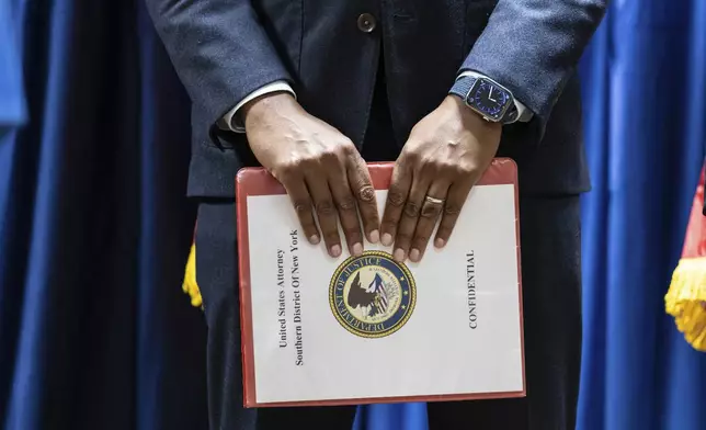 Damian Williams, U.S. Attorney for the Southern District of New York, holds a binder marked confidential during a press conference at Federal Plaza in New York, Monday Sept. 16, 2024, following the arrest of two former New York City Fire Department chiefs. (AP Photo/Stefan Jeremiah)