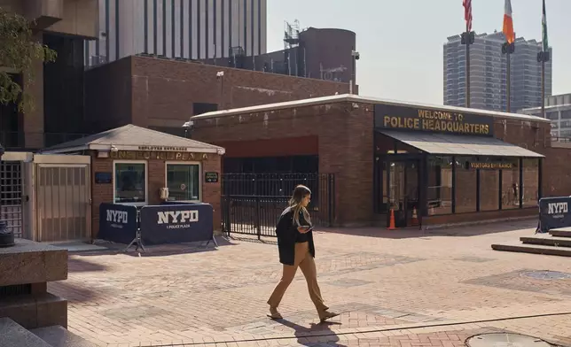 A woman walks outside One Police Plaza NYPD Headquarters on Friday, Sept. 13, 2024, in New York. (AP Photo/Andres Kudacki)