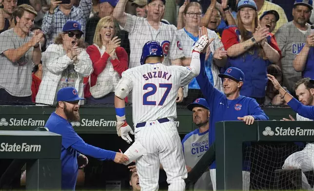 Chicago Cubs designated hitter Seiya Suzuki, center, high-fives manager Craig Counsell after hitting a two-run home run during the third inning of a baseball game against the Washington Nationals, Thursday, Sept. 19, 2024, in Chicago. (AP Photo/Erin Hooley)