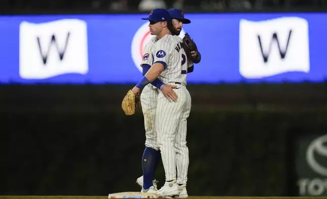 Chicago Cubs shortstop Dansby Swanson, left, and second baseman Nico Hoerner celebrate after their win over the Washington Nationals in a baseball game Thursday, Sept. 19, 2024, in Chicago. (AP Photo/Erin Hooley)