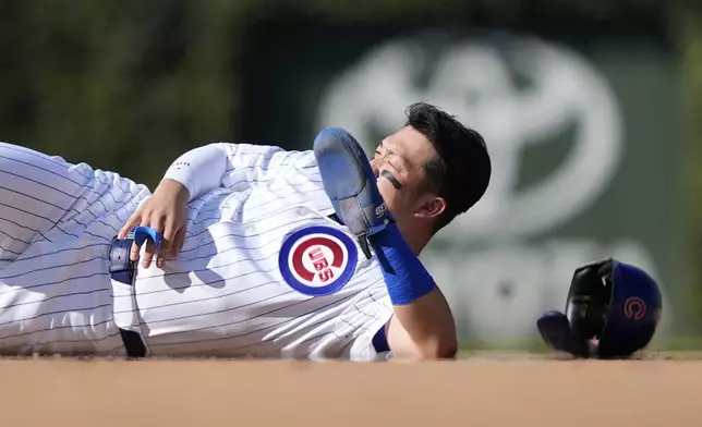 Chicago Cubs Seiya Suzuki lays in the ground after being hit by Washington Nationals catcher Drew Millas' throw to second as Suzuki stole the base during the eighth inning of a baseball game Friday, Sept. 20, 2024, in Chicago. (AP Photo/Charles Rex Arbogast)