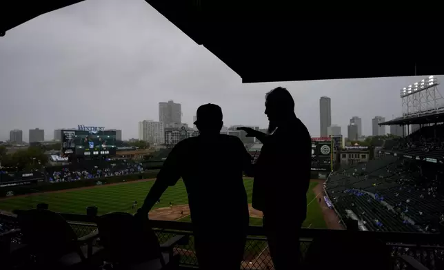 Fans wait during a rain delay before a baseball game between the Washington Nationals and the Chicago Cubs in Chicago, Sunday, Sept. 22, 2024. (AP Photo/Nam Y. Huh)