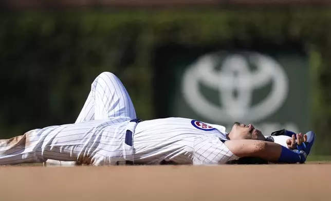 Chicago Cubs Seiya Suzuki lays in the ground after being hit by Washington Nationals catcher Drew Millas' throw to second as Suzuki stole the base during the eighth inning of a baseball game Friday, Sept. 20, 2024, in Chicago. (AP Photo/Charles Rex Arbogast)