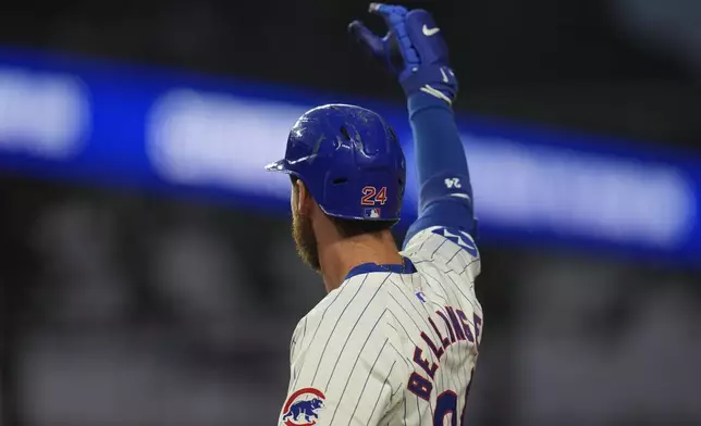 Chicago Cubs' Cody Bellinger signals to the dugout after hitting a single, allowing Dansby Swanson to score, during the first inning of a baseball game against the Washington Nationals, Thursday, Sept. 19, 2024, in Chicago. (AP Photo/Erin Hooley)