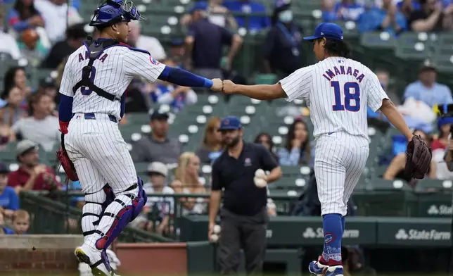 Chicago Cubs starting pitcher Shota Imanaga, right, of Japan, is congratulated by catcher Miguel Amaya, left, as they walk to the dugout after the second inning of a baseball game against the Washington Nationals in Chicago, Sunday, Sept. 22, 2024. (AP Photo/Nam Y. Huh)