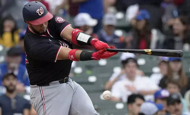 Washington Nationals' Keibert Ruiz swings and strikes out on a foul tip during the second inning of a baseball game against the Chicago Cubs in Chicago, Sunday, Sept. 22, 2024. (AP Photo/Nam Y. Huh)