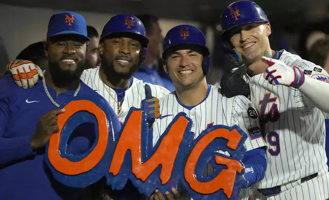 From left, New York Mets' Luis Severino, Starling Marte, Jose Iglesias, and Brandon Nimmo pose with a sign after Nimmo hit a two-run home run during the fourth inning of a baseball game against the Washington Nationals, Wednesday, Sept. 18, 2024, in New York. (AP Photo/Pamela Smith)