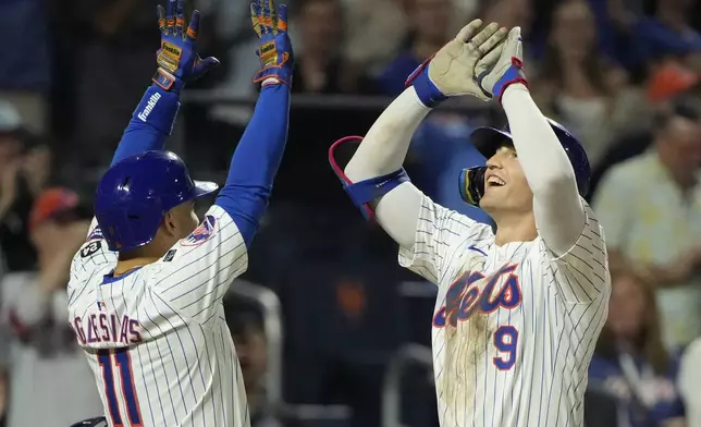 New York Mets' Jose Iglesias, left, and Brandon Nimmo, react after Nimmo hit a home run leading Iglesias and Starling Marte to score during the fourth inning of a baseball game against the Washington Nationals, Wednesday, Sept. 18, 2024, in New York. (AP Photo/Pamela Smith)