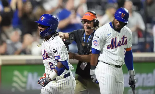 New York Mets' Luisangel Acuña (2) celebrates with Starling Marte, right, after hitting a home run during the eighth inning of a baseball game against the Washington Nationals, Tuesday, Sept. 17, 2024, in New York. (AP Photo/Frank Franklin II)