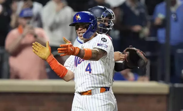 New York Mets' Francisco Alvarez celebrates as he passes Washington Nationals catcher Keibert Ruiz after hitting a home run during the fourth inning of a baseball game, Tuesday, Sept. 17, 2024, in New York. (AP Photo/Frank Franklin II)