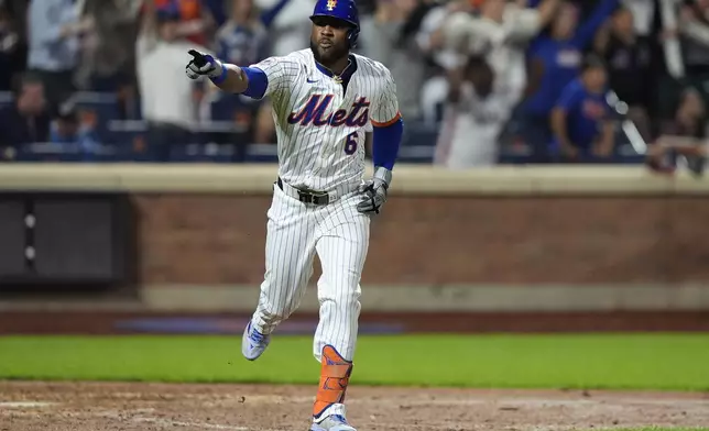 New York Mets' Starling Marte gestures as he runs to first base after hitting an RBI single during the 10th inning of a baseball game against the Washington Nationals, Monday, Sept. 16, 2024, in New York. (AP Photo/Frank Franklin II)