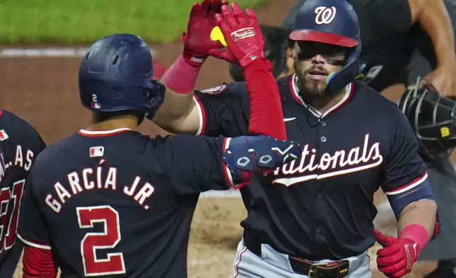 Washington Nationals' Andrés Chaparro, right, celebrates with Luis García Jr. (2) as he returns to the dugout after hitting a two-run home run off Pittsburgh Pirates relief pitcher Ryan Borucki during the seventh inning of the second baseball game of a doubleheader in Pittsburgh, Saturday, Sept. 7, 2024. (AP Photo/Gene J. Puskar)