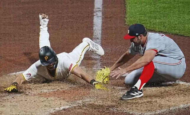 Pittsburgh Pirates' Jared Triolo, left, scores on a wild pitch by Washington Nationals relief pitcher Joe La Sorsa, right, during the sixth inning of a baseball game in Pittsburgh, Thursday, Sept. 5, 2024. (AP Photo/Gene J. Puskar)