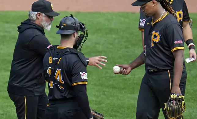 Pittsburgh Pirates starting pitcher Luis L. Ortiz, right, hands the ball to manager Derek Shelton, left, during the sixth inning of the first baseball game of a split doubleheader against the Washington Nationals in Pittsburgh, Saturday, Sept. 7, 2024. (AP Photo/Gene J. Puskar)