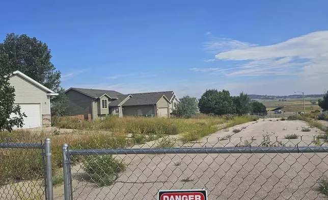 This photo taken April 27, 2022, by Tonya Junker shows a fence prohibiting people to enter due to a sinkhole in the Hideaway Hills neighborhood near Rapid City, S.D. (Tonya Junker via AP)