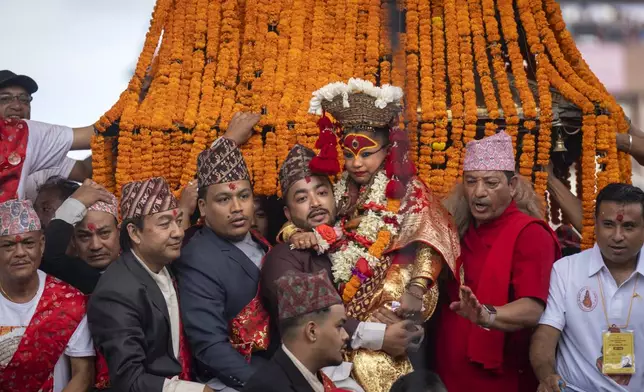 Living goddess Kumari reacts as she is being carried during Indra Jatra, a festival that marks the end of the rainy season in Kathmandu, Nepal, Tuesday, Sept. 17, 2024. (AP Photo/Niranjan Shrestha)