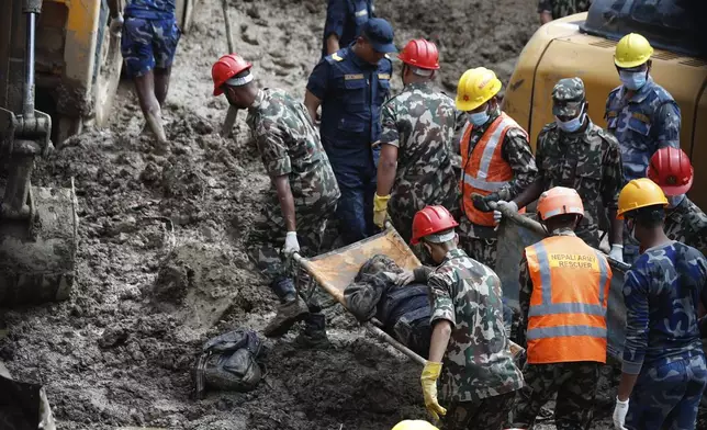 EDS NOTE: GRAPHIC CONTENT - Rescue personnel transport the dead body of a victim who was trapped under a landslide caused by heavy rains in Kathmandu, Nepal, Sunday, Sept. 29, 2024. (AP Photo/Sujan Gurung)