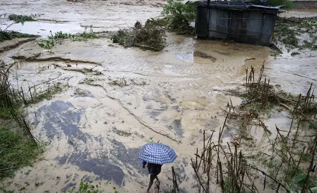 A man walks on the shore of the flooded Bagmati River after heavy rains in Kathmandu, Nepal, Saturday, Sept. 28, 2024. (AP Photo/Gopen Rai)