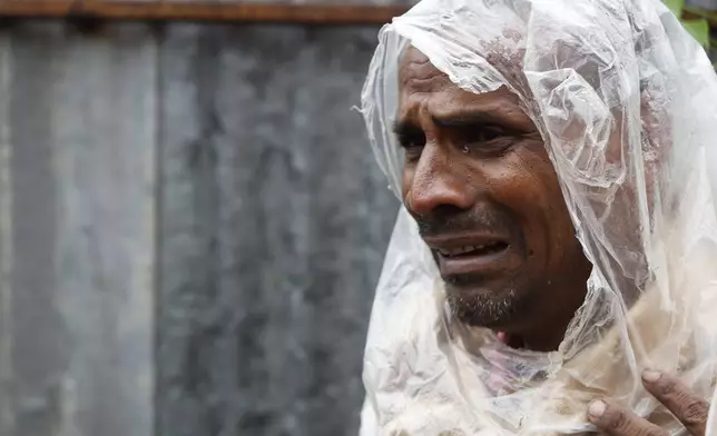 Hridesh Sah, 40, mourns the death of his nephew, who was found dead near a scrap collection site on the outskirts of Kathmandu after the shed he was sleeping under was flooded due to heavy rains in the country's capital, Nepal, Saturday, Sept. 28, 2024. (AP Photo/Gopen Rai)