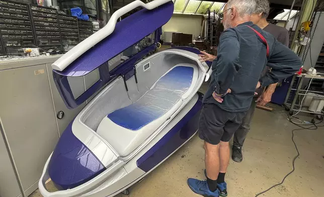 Philip Nitschke, front, stands next to a 'suicide pod' known as 'The Sarco' in Rotterdam, The Netherlands, July 8, 2024. (AP Photo/Ahmad Seir)