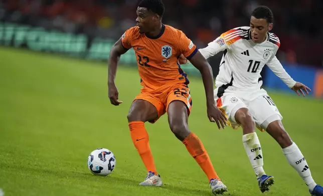 Denzel Dumfries of the Netherlands, left, and Germany's Jamal Musiala fight for the ba;; during the UEFA Nations League soccer match between Netherlands and Germany in Amsterdam, Netherlands, on Tuesday, Sept. 10, 2024. (AP Photo/Peter Dejong)